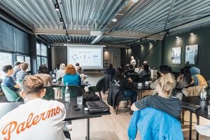 A diverse group attending an educational workshop indoors, focused on a presentation.
